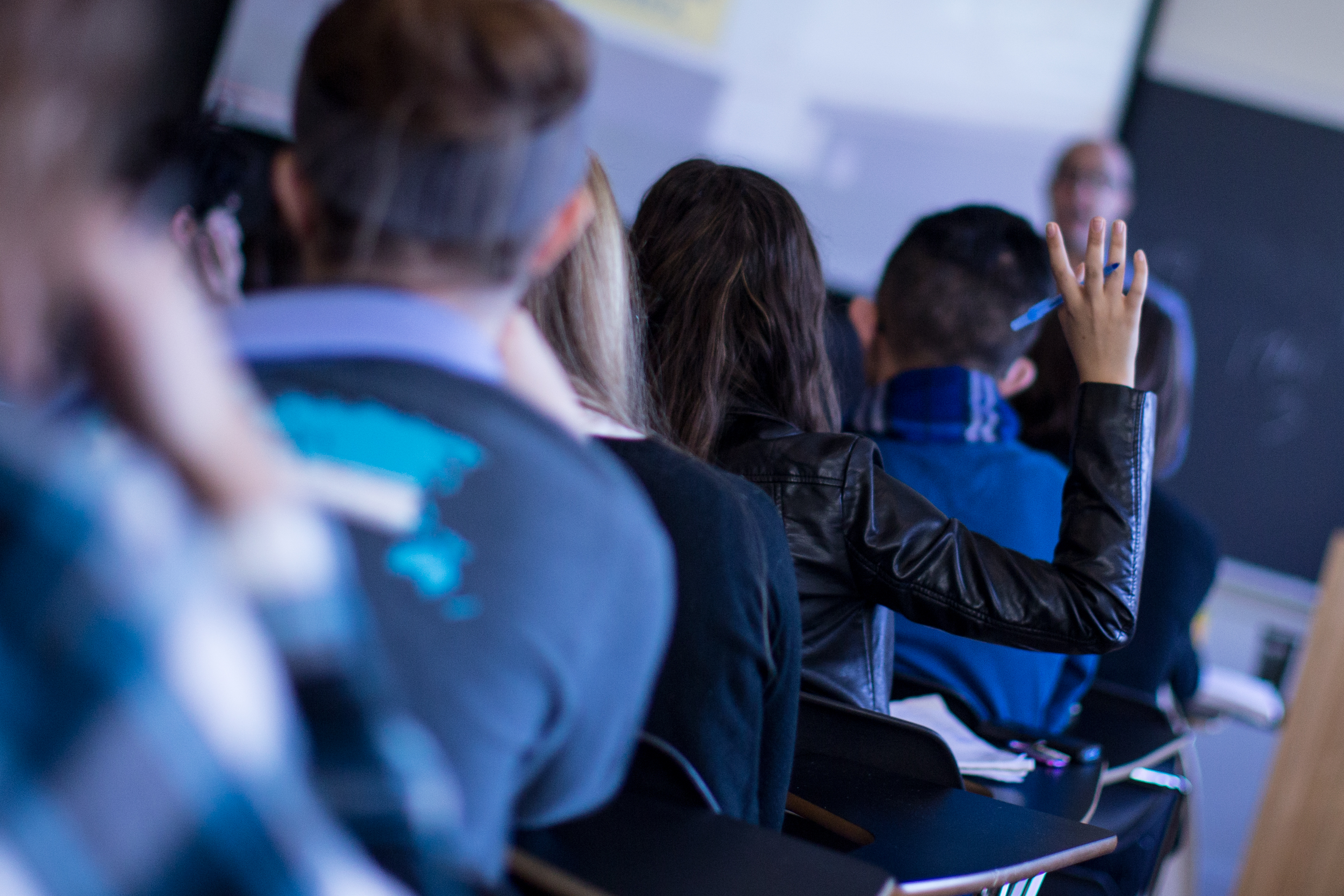 student raising their hand to speak in class